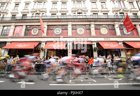 Les cavaliers font leur chemin passé Hamleys Toy Store lors de l'étape 8 de l'Ovo Energy Tour of Britain 2018 autour de Londres. Banque D'Images