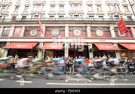 Les cavaliers font leur chemin passé Hamleys Toy Store lors de l'étape 8 de l'Ovo Energy Tour of Britain 2018 autour de Londres. Banque D'Images