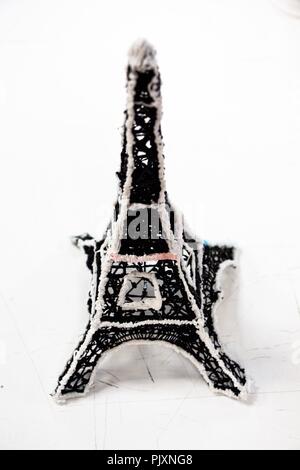 Petit Tour Eiffel sur fond blanc. La conception est faite de leur plastique en miniature. Banque D'Images