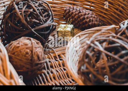 Dans un panier qui est tissé à partir d'une vigne, il y a des balles qui sont aussi tissés à partir d'une vigne et le cône de conifères. Entre eux est un petit fort packe Banque D'Images