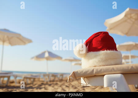 Santa Claus hat sur la plage le jour de Noël. Banque D'Images