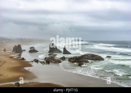 Bandon Beach donnent sur la mer ou le paysage avec des piles d'affleurements rocheux le long de la côte sous un ciel couvert jour pluvieux, côte de l'Oregon, USA. Banque D'Images