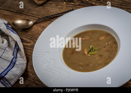 Lentilles brunes avec saucisse sop sur table en bois Banque D'Images