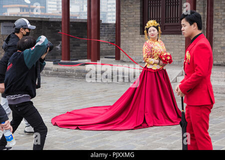 XIAN, CHINE - 10 mars 2018 - photographe chinois prend des photos de mariage pour le couple sur le dessus de la ville de Xian mur dans Xi'an, Chine le 10 mars Banque D'Images
