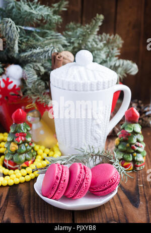 Macarons rose avec des décorations de Noël et la coupe blanche sur fond de bois Banque D'Images