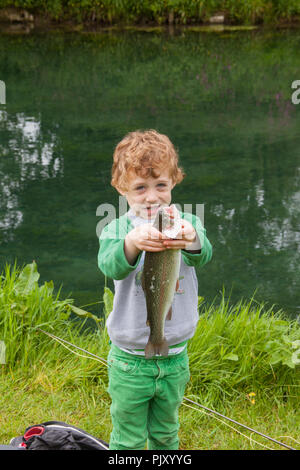 Garçon de quatre ans à Meon Springs Trout pêcherie, East Meon, Hampshire, Angleterre, Royaume-Uni. Banque D'Images