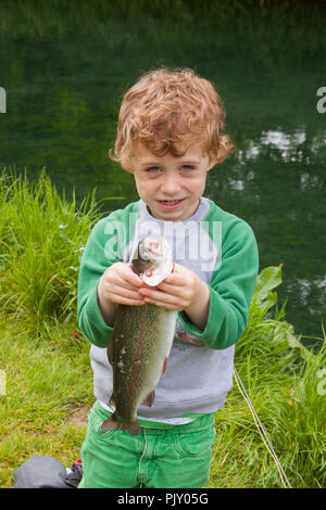 Garçon de quatre ans à Meon Springs Trout pêcherie, East Meon, Hampshire, Angleterre, Royaume-Uni. Banque D'Images