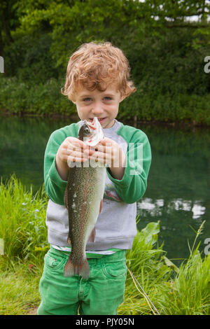 Garçon de quatre ans à Meon Springs Trout pêcherie, East Meon, Hampshire, Angleterre, Royaume-Uni. Banque D'Images