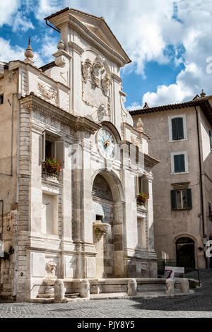 L'ancienne fontaine de travertin de la Piazza del Mercato avec l'ancienne tour de l'horloge artistique. Spoleto - UMBRIA, Italie Banque D'Images