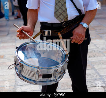 Musicien joue un tambour dans la rue pendant un événement religieux Banque D'Images