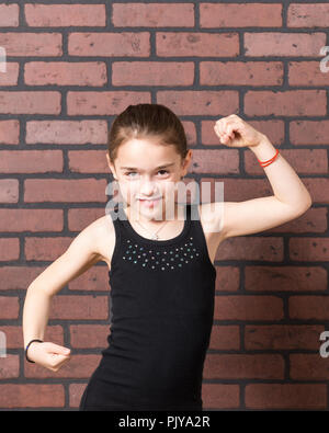 Jeune fille avec une moustache de lait gesticulant devant expressivement un mur arrière-plan. Banque D'Images