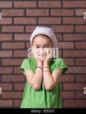 Jeune fille avec une moustache de lait gesticulant devant expressivement un mur arrière-plan. Banque D'Images