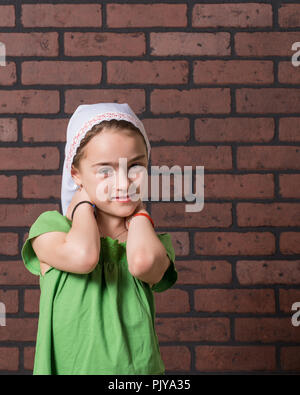 Jeune fille avec une moustache de lait gesticulant devant expressivement un mur arrière-plan. Banque D'Images