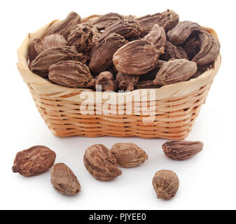 Cardamome noire dans un panier sur fond blanc Banque D'Images