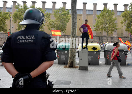 Barcelone, Catalogne, Espagne. Sep 9, 2018. Un agent de la police catalane vu veillant sur un manifestant debout sur une boîte d'électricité pendant la manifestation.Quelque 2 000 personnes, selon la police locale a démontré à Barcelone en faveur de l'unité de l'Espagne et contre l'indépendance de la Catalogne sous le slogan ; récupérer la dignité. Une contre-manifestation d'une centaine de personnes, convoquées par les anti-fascistes et les mouvements d'indépendance ont également eu lieu autour de la place d'Espagne et dans le cadre d'un dispositif solide qu'ils ont été empêchés de s'affronter mais les insultes est devenue plus grande. (Crédit Image : Banque D'Images