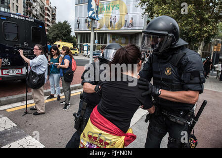 9 Septembre, 2018 - Barcelone, Catalogne/Espagne, Espagne - Deux agents de police catalane vu l'arrestation d'une femme avec le drapeau espagnol qui a tenté de franchir le cordon de sécurité de réprimander la lutte antifasciste pendant la manifestation en faveur de l'unité de l'Espagne.Quelque 2 000 personnes, selon la police locale a démontré à Barcelone en faveur de l'unité de l'Espagne et contre l'indépendance de la Catalogne sous le slogan ; récupérer la dignité. Une contre-manifestation d'une centaine de personnes, convoquées par les anti-fascistes et les mouvements d'indépendance ont également eu lieu autour de la place d'Espagne et dans le cadre d'un dispositif solide ils Banque D'Images