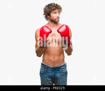 Handsome young man wearing boxing gloves boxer sur fond isolé smiling à côté et regardant loin de penser. Banque D'Images