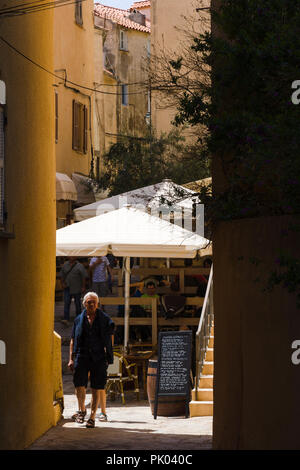 Ruelle étroite avec restaurant en plein air en patio citadelle de Calvi, Corse, France Banque D'Images