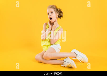 Portrait d'une fille en short blanc et jaune d'un sujet. Banque D'Images