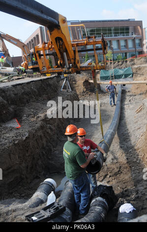 Tuyau de pose sur un chantier de construction. Banque D'Images