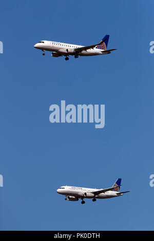 LR 170 Embraer ERJ (N151SY) exploité par SkyWest Airlines pour United Express et de l'Airbus A320-232 (N448UA) effectués par United Airlines sur une approche parallèle à l'Aéroport International de San Francisco (KSFO), San Francisco, Californie, États-Unis d'Amérique Banque D'Images