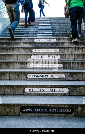 Les gens de quitter la station de métro Spittelmarkt avec plaques à la publicité sur chaque étape de l'escaliers de sortie à Berlin, Allemagne Banque D'Images