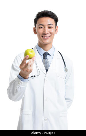 Cheerful young doctor holding apple Banque D'Images