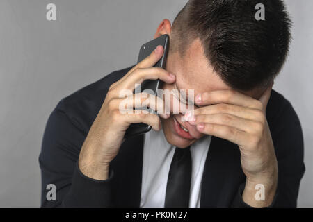 Portrait d'un jeune homme émotionnellement parlant au téléphone Banque D'Images