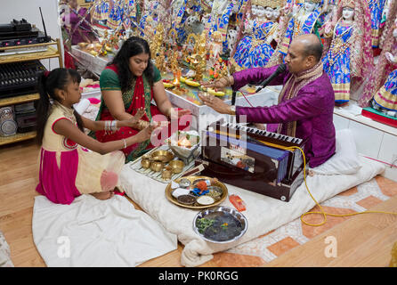 Un pandit hindou effectuant un service de prière dans un petit temple dans le sous-sol de sa maison dans le sud de Richmond Hill, Queens, New York. Banque D'Images