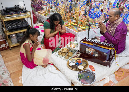 Un pandit hindou effectuant un service de prière dans un petit temple dans le sous-sol de sa maison dans le sud de Richmond Hill, Queens, New York. Banque D'Images