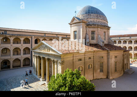 La chapelle baroque couronnée par un dôme à l'ellipsoïde et la façade d'un portique dans la cour de l'ancien hospice de La Vieille Charité à Marseille. Banque D'Images