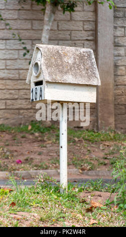 Une vue latérale d'un vieux white post box sur un support de mousse et de moisissure sur le toit Banque D'Images