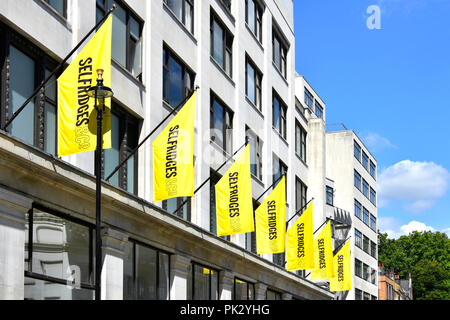 La rue commerçante de Londres bannière jaune au-dessus de la rue Duke bâtiment annexe, derrière le célèbre grand magasin Selfridges Oxford Street en Angleterre Banque D'Images