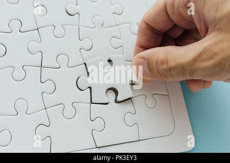 Pièce manquante du puzzle. L'homme a réussi à résoudre un puzzle, mettre la main dernier élément pour compléter la solution Banque D'Images