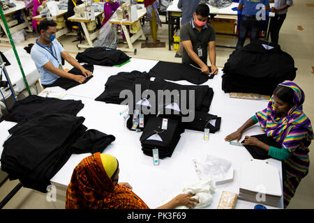 Les travailleurs du vêtement Vêtements de pliage à l'intérieur d'une usine de confection au Bangladesh. Banque D'Images