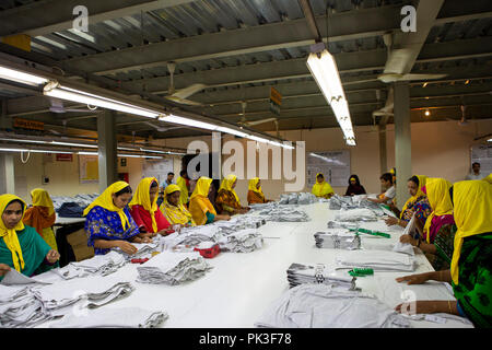 Un groupe de femmes travailleuses du vêtement Vêtements de pliage à l'intérieur d'une usine de confection au Bangladesh. Banque D'Images