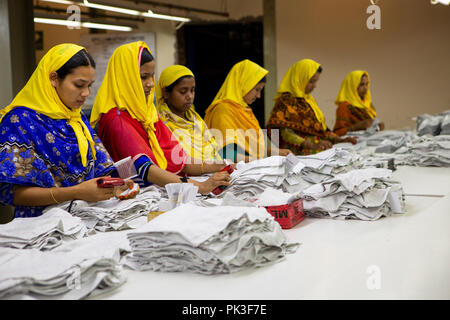 Un groupe de femmes travailleuses du vêtement Vêtements de pliage à l'intérieur d'une usine de confection au Bangladesh. Banque D'Images