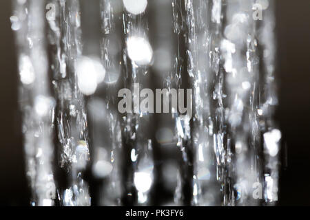 Robinet lumineux de l'eau pulvérisée avec fond noir Banque D'Images