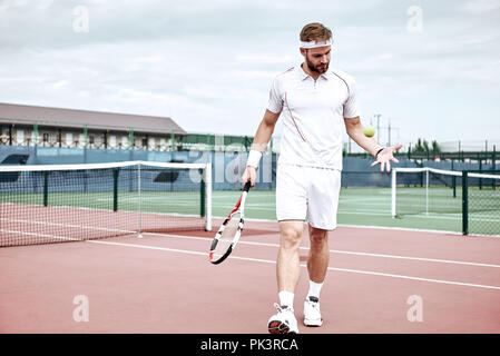 Portrait of young caucasian teenis player portant robe tennis, marche sur tennis hardcourt, journée d'été à l'extérieur. Fashion portrait tirer. Mode sport Banque D'Images