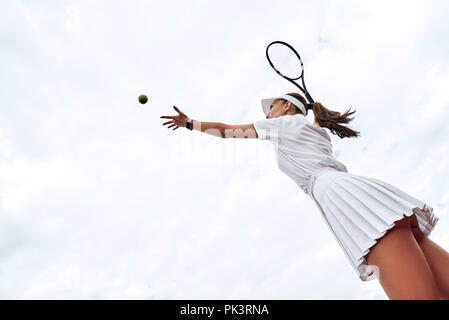 Vue arrière du joueur de tennis femme servant au cours d'un jeu Banque D'Images