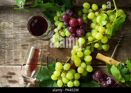 Fond de vin. Dans les verres de vin rouge, bouteille, raisins sur fond vintage, vin concept. Vue de dessus, l'espace de copie mise à plat arrière-plan. Banque D'Images