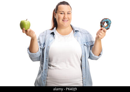 L'excès de femme tenant une pomme et un beigne isolé sur fond blanc Banque D'Images