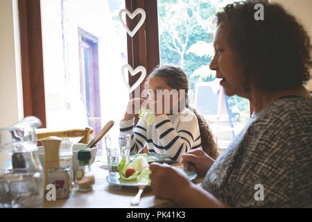 Grand-mère et petite-fille d'un repas sur table à manger Banque D'Images