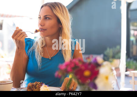 Woman having breakfast in outdoor cafe Banque D'Images