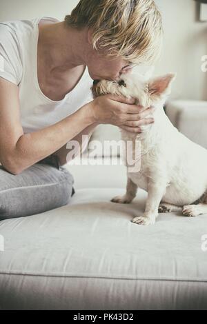 Vieille Femme embrassant un chien Banque D'Images