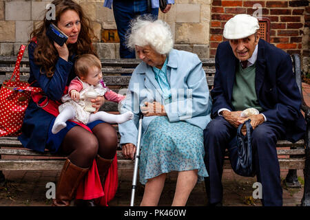 Les gens assis sur un banc public, High Street, Lewes, East Sussex, UK Banque D'Images