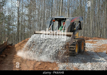 Route Chemin de mise à niveau pour l'entrée en pierre et petit bobcat en Géorgie pour la construction d'une maison familiale par un entrepreneur en construction au-dessus d'enrochements Banque D'Images