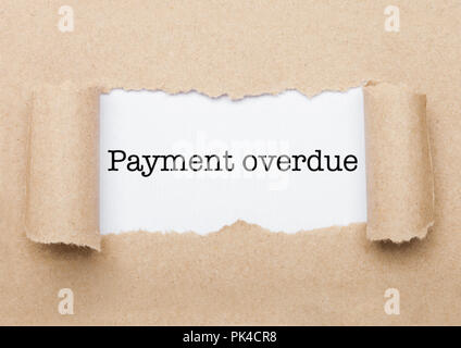 Retard de paiement texte concept apparaître derrière l'enveloppe de papier brun déchiré Banque D'Images