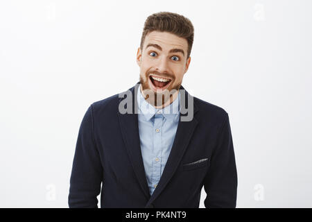 Jusqu'à la taille de balle enchanté et enthousiaste jeune surpris en baccalauréat riche costume élégant avec de la barbe et des yeux bleus tout sourire d'étonnement et de joie le regard impressionné at camera Banque D'Images