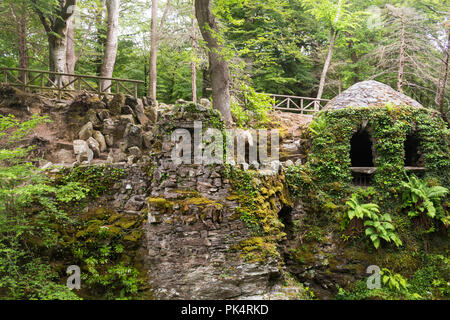 L'Ermitage à Tollymore Forest Park, est un joli abri en pierre recouvert de lierre sur un fleuve le long de la rivière de Shima, Newcastle, comté de Down, N. Banque D'Images